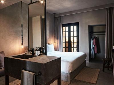 Habitación de hotel moderna con cama grande y ventana con cortinas.