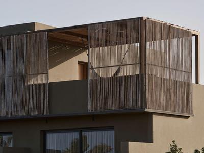 Modern two-story building with wooden cladding on the upper floor and glass sliding doors on the ground floor.