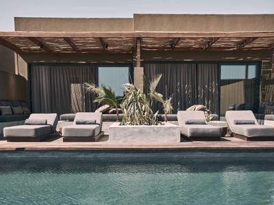 Modern hotel terrace with pool, six sun loungers, and plants under a wooden pergola.