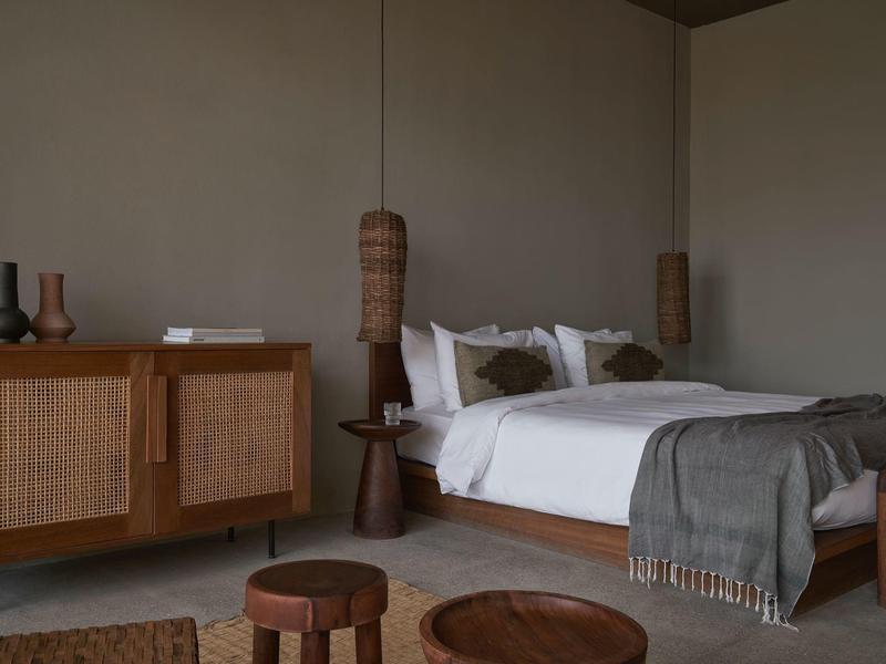 Modern eingerichtetes Schlafzimmer mit Doppelbett, Holzmöbeln und warmem Licht.