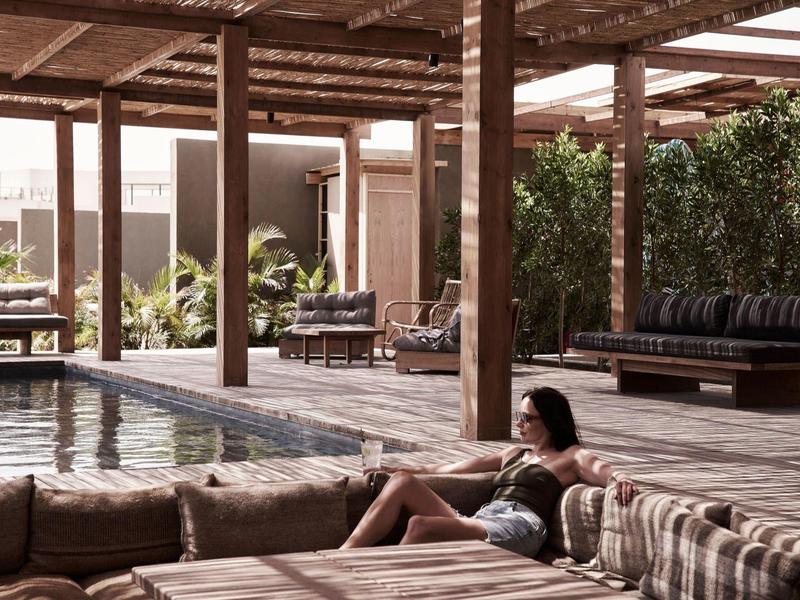 Gemütlicher Lounge-Bereich mit Säulen und Pool im Hintergrund in einem Hotel.