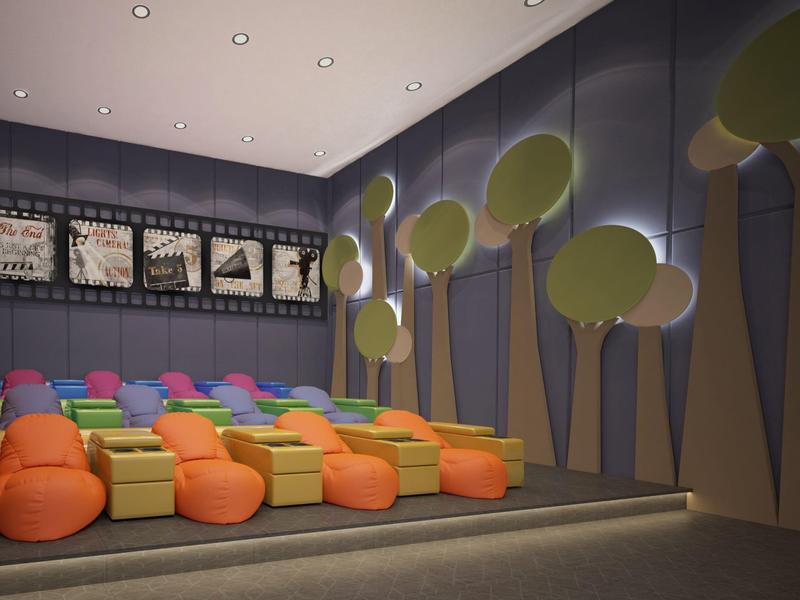 Modern hotel cinema with colorful bean bag seats and tree-shaped wall decorations.