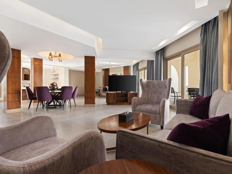 Modern hotel lounge with comfortable armchairs, coffee tables, and spacious seating areas.