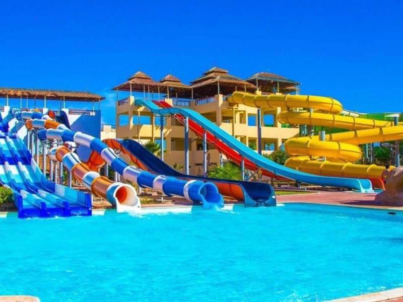 Large outdoor water park with multiple colorful water slides and clear blue pool water.