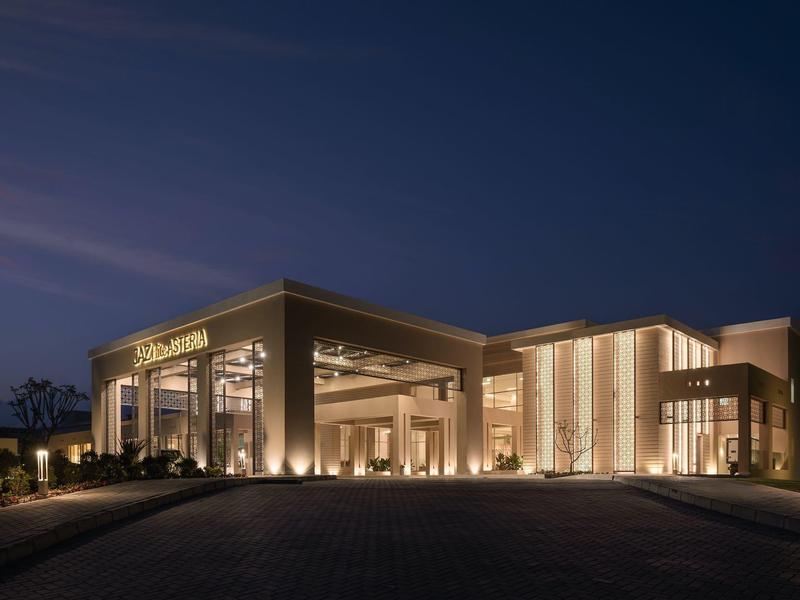 Bâtiment d'hôtel moderne la nuit avec des fenêtres éclairées chaleureusement et ciel clair.
