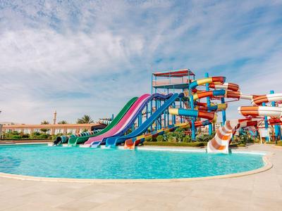 Large water park with colorful water slides and clear pool under a blue sky.