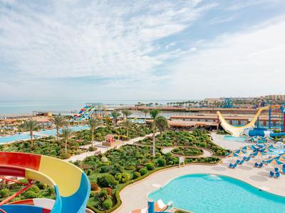 Resort with pool, water slides, and hotel buildings under a blue sky.