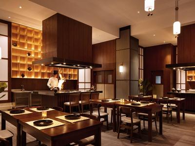 Elegant hotel restaurant with dark wood, modern design, and warm lighting.