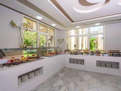 Buffet moderne avec une variété de plats dans une salle à manger d'hôtel lumineuse et élégante.