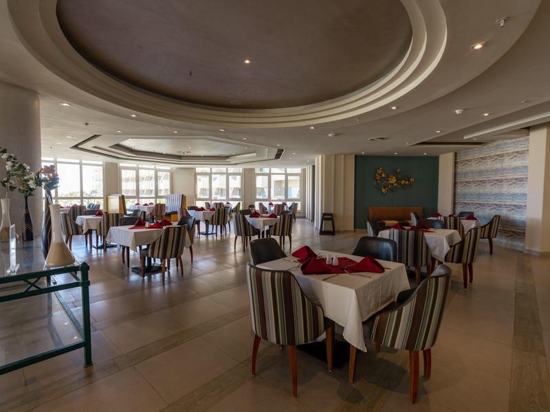 Salle à manger élégante avec tables rondes et chaises confortables dans un cadre lumineux.