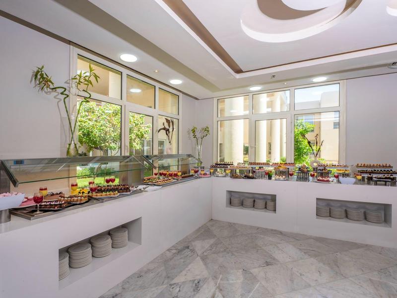 Buffet moderne avec une variété de plats dans une salle à manger d'hôtel lumineuse et élégante.