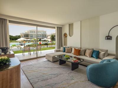 Bright hotel lounge with modern decor and a view of the pool and outdoor area.