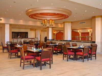 Amplio comedor con mesas de madera y sillas rojas en un restaurante de hotel.