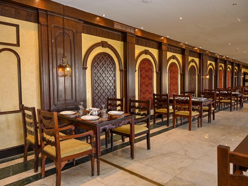 Mesas puestas en un elegante restaurante con paredes de madera y sillas.