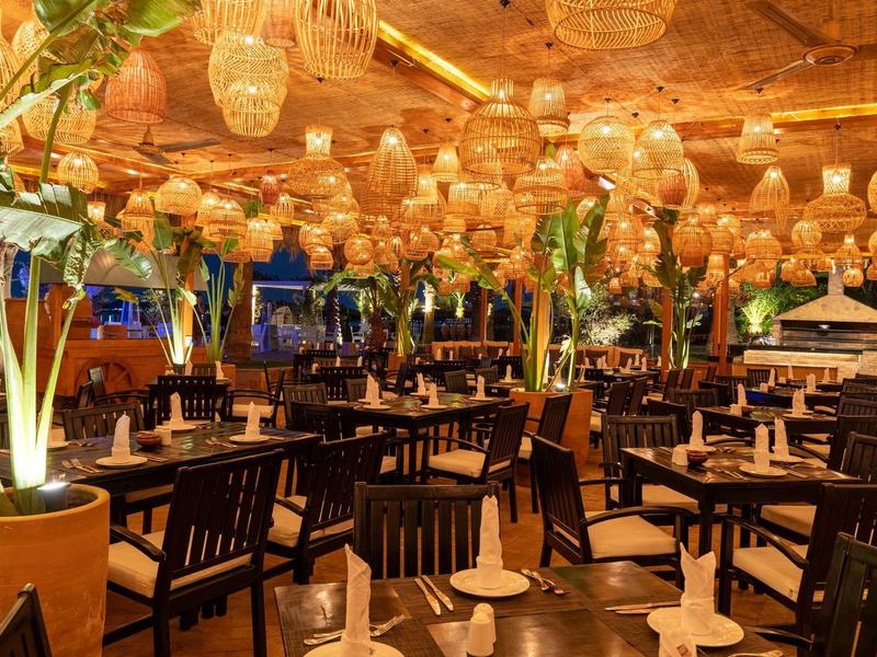 Restaurant chaleureux avec mobilier en bois et éclairage doux dans un lieu de vacances.