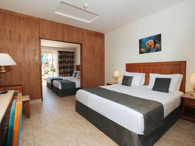 Chambre d'hôtel moderne avec lit double, bureau et espace attenant avec un lit simple.