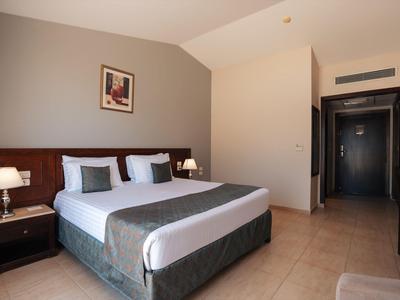 Modern hotelkamer met tweepersoonsbed, nachtkastjes en eenvoudige decoratie.