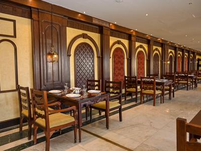 Elegant restaurant met houten meubels en warme wandverlichting in een hotel.