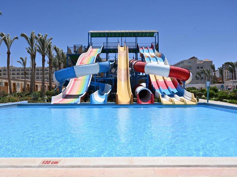 Scivoli d'acqua colorati che sfociano in una grande piscina con acqua limpida e azzurra.