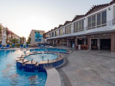 Espace piscine moderne avec toboggans et bâtiments d'hôtel au coucher du soleil