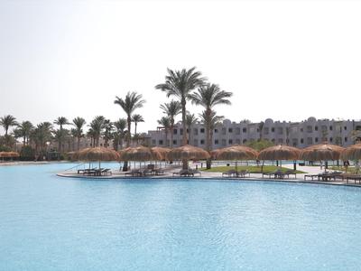 Grande piscina con palme e edifici sullo sfondo sotto un cielo limpido