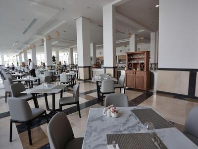 Prostorná, světlá jídelna s moderními stoly a židlemi v hotelu.