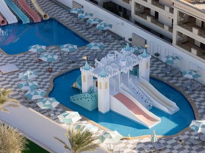 Parco acquatico con castello colorato e scivoli nell'area piscina di un hotel.