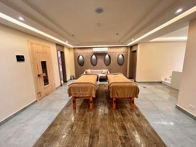 Elegante sala spa con due lettini da massaggio e illuminazione rilassante.