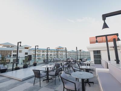 Area esterna moderna con tavoli e sedie su una terrazza dell'hotel alla luce del giorno