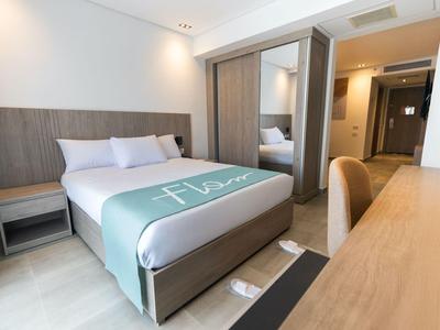 Camera d'hotel moderna con letto grande, scrivania e specchio a parete.