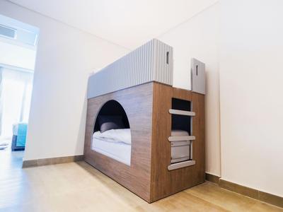 Letto a castello compatto con struttura in legno e tenda in una camera d'hotel moderna.