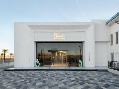 Ingresso d'hotel moderno con facciata in vetro e pareti bianche pulite sotto un cielo blu