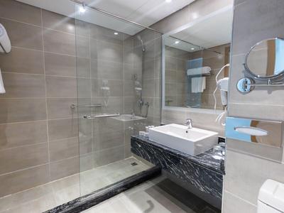 Modernes Badezimmer mit Dusche, Waschbecken und Spiegel in neutralen Farben.