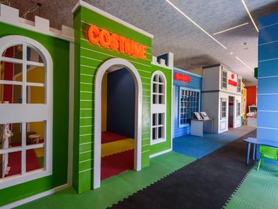 Bunter Indoor-Spielbereich mit verschiedenen Themenhäusern für Kinder