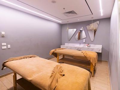 Moderner Spa-Raum mit zwei Massageliegen und gedämpftem Licht.