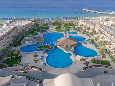 Großer Hotelpool mit mehreren verbundenen Becken und Poolbar am Meer