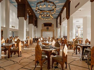 Helles, geräumiges Restaurant mit Holzmöbeln und großen Kronleuchtern.