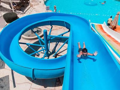 Toboggan aquatique dans une piscine d'hôtel avec deux personnes glissant dans l'eau.