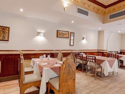 Stilvolles Restaurant mit gedeckten Tischen, Holzmöbeln und warmem Ambiente.