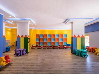 Bunter Kinderspielraum mit Sitzgelegenheiten und farbenfrohen Wandregalen.