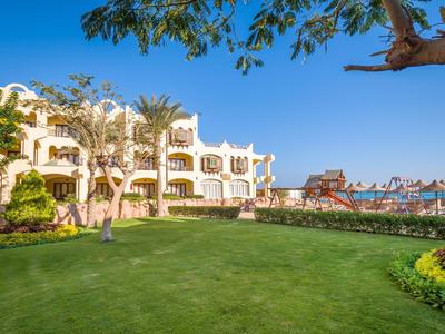Hotel mit Rasenfläche und Blick auf das Meer bei klarem Himmel