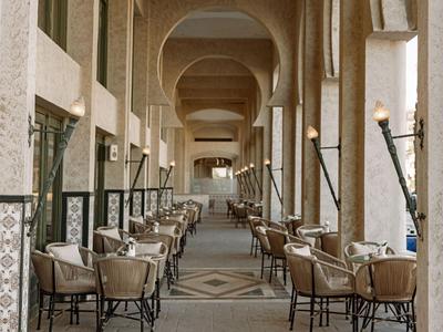 Überdachter Restaurantbereich mit Tischen, Stühlen und traditioneller Dekoration in warmen Tönen.