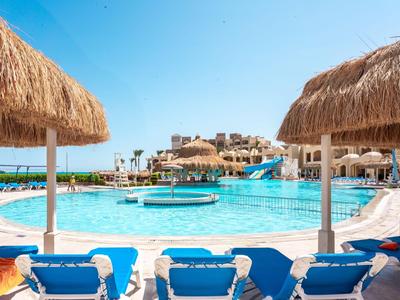 Großer Pool mit Sonnenschirmen, Liegestühlen und einem Wasserspielbereich in einem Resort.