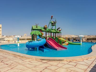Kinderpool mit bunten Rutschen und Wasserspielplatz unter klarem blauem Himmel.