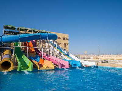 Bunte Wasserrutschen führen in einen großen Pool unter blauem Himmel.