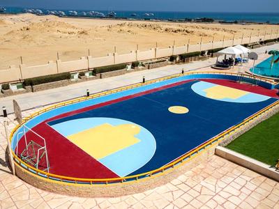 Colorful hockey field next to hotel with desert and sea views.