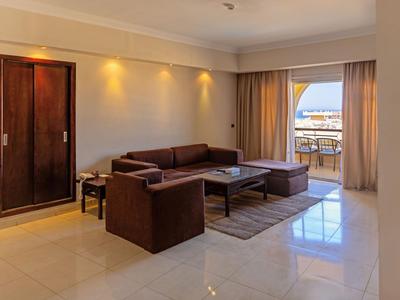 Helles Wohnzimmer mit brauem Sofa, Tisch, Teppich und Balkon mit Meerblick