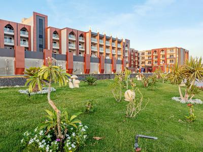 Moderní hotelová budova s upraveným zeleným trávníkem a dekorativními rostlinami