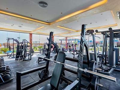 Moderní posilovna s různými posilovacími stroji a výhledem ven.