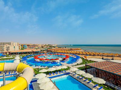 Velký vodní park s bazény, tobogány a výhledem na moře za slunečného dne.